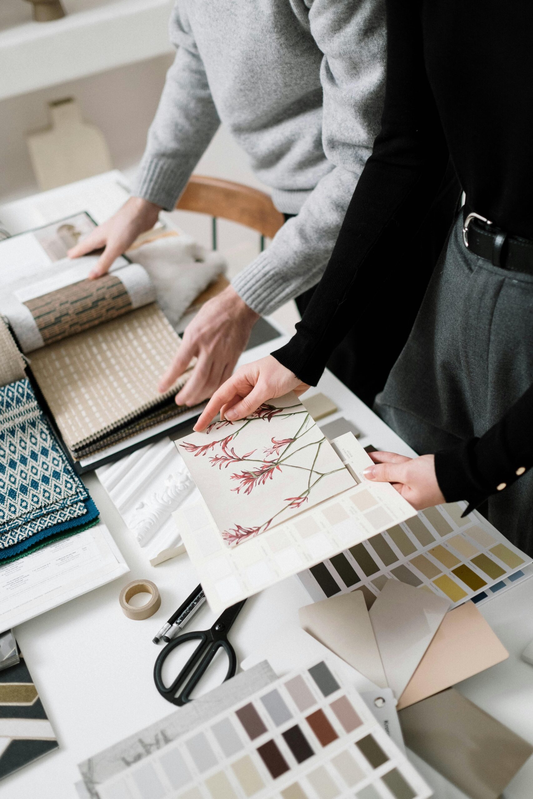 Interior designers collaborating with fabric samples and color swatches for a project.